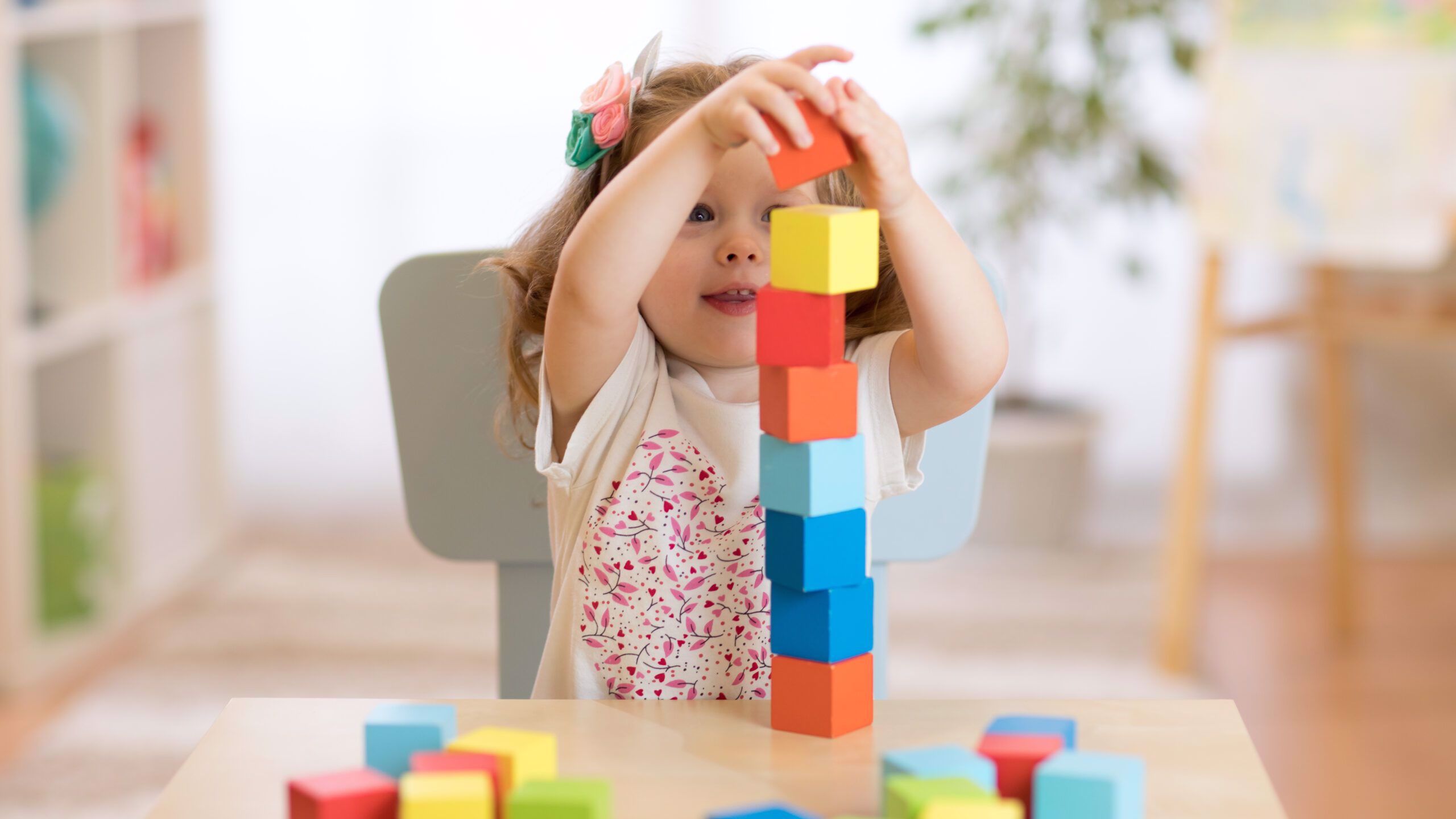 A young girl playing with building blocks
