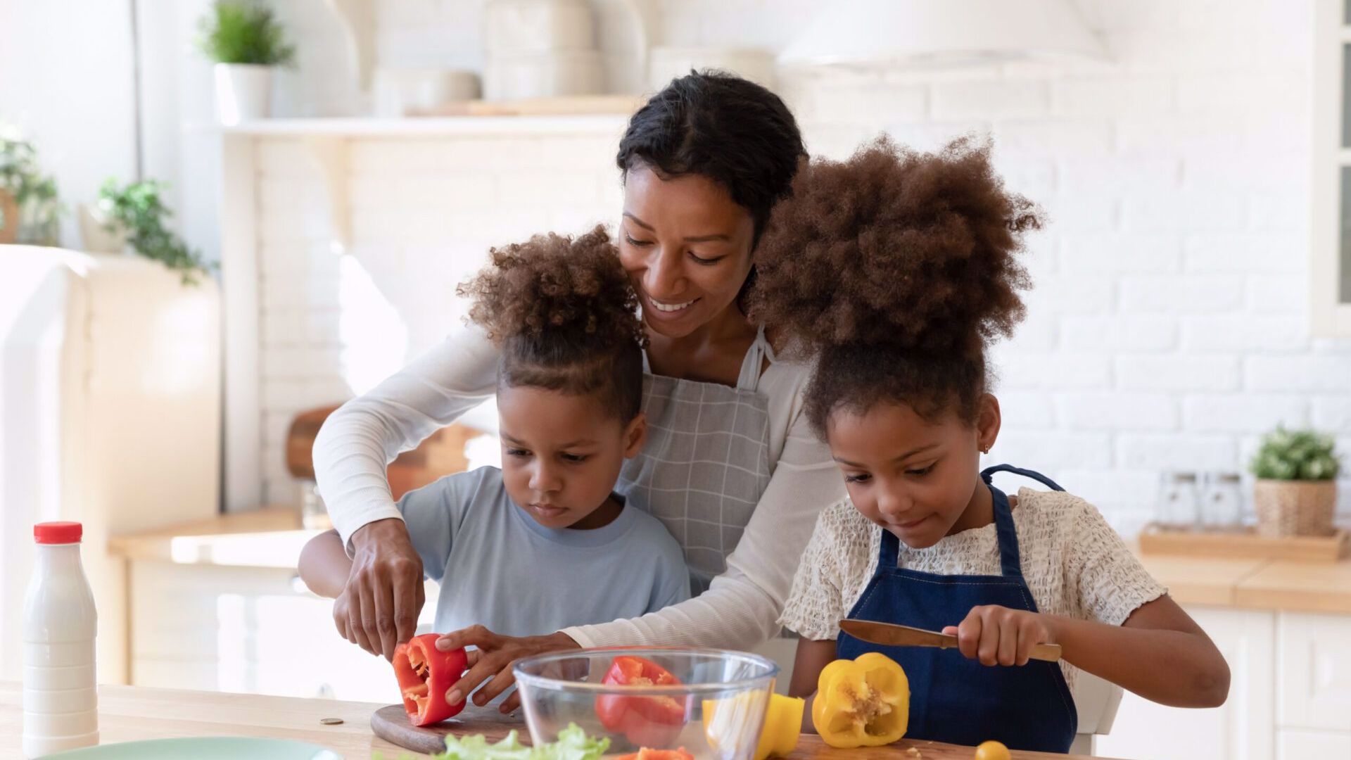 Two children and an adult preparing food