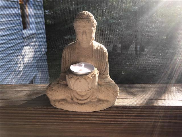 Buddha statue with unlit tea light
