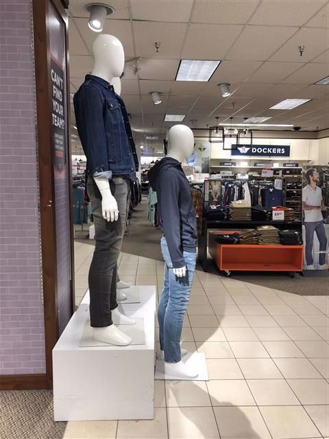 Misaligned mannequins in a storefront