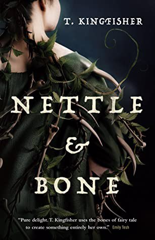 Cover of Nettle & Bone by T. Kingfisher. A white woman stands facing away from the reader, wearing a cloak of green leaves and long spikes.