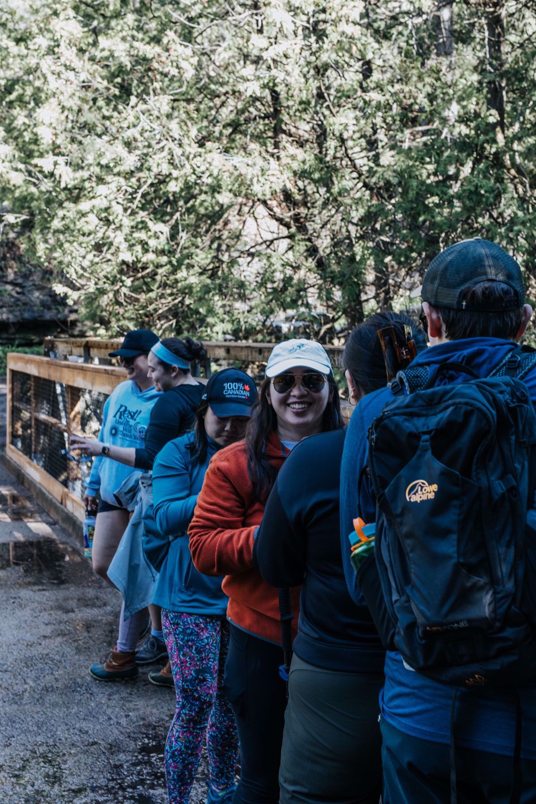 A picture of a marsh area. There is a dark waterway through the middle, and there are dry reeds and grasses as well as some large logs in the water. It is a sunny day. 