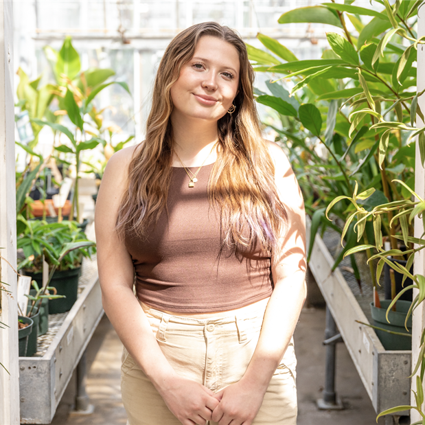 Photo of Jailyn in a greenhouse