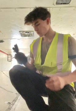 Young man kneeling and looking at small tool