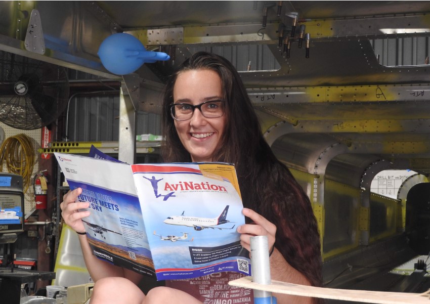 Young lady reading magazine in workshop