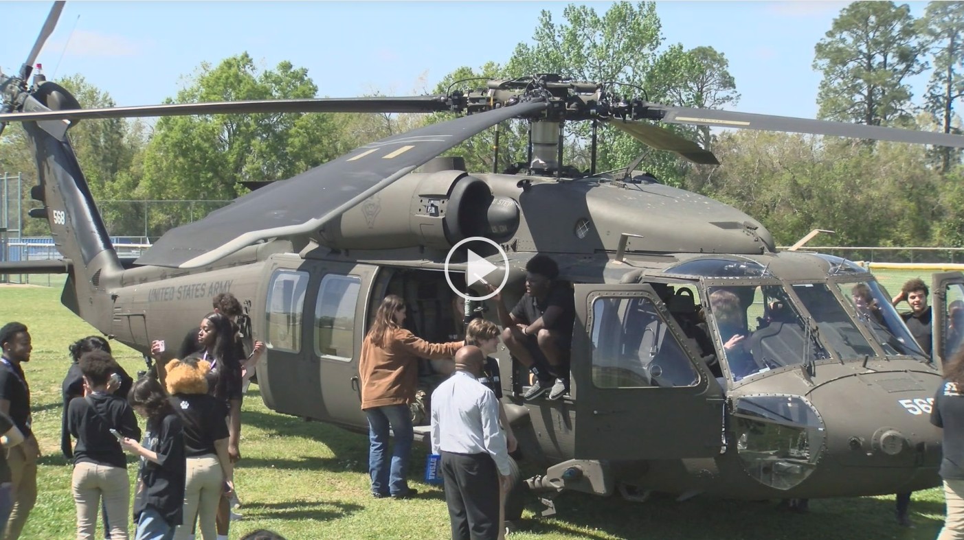 Helicopter on ground with people closeby looking inside