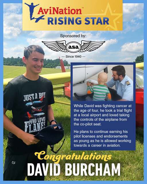 Photo of young man standing in a field beside aircraft