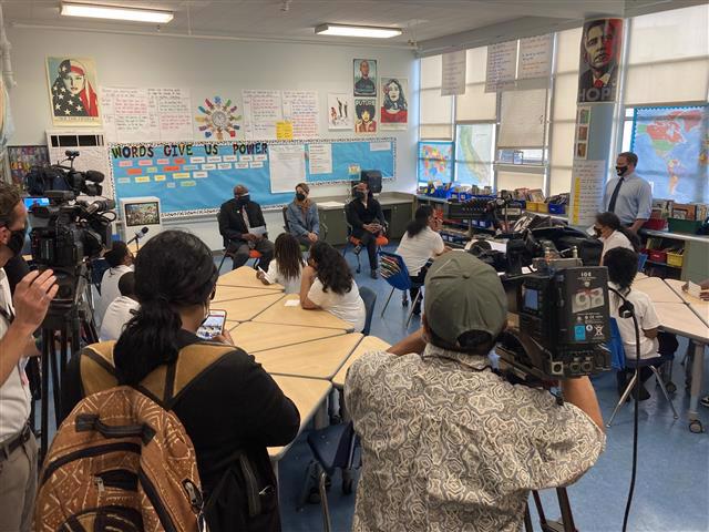 Superintendent Matthews, Board President Lopez, Dr. Woolridge of UCSF and students at Malcolm X Academy engage in a Q&A about the COVID vaccine. Media are in the background.