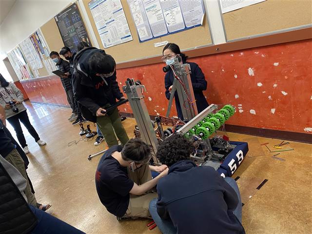 Lowell students building a robot in school hallway