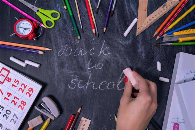 Photo of school supplies with chalk writing saying "Back to school"