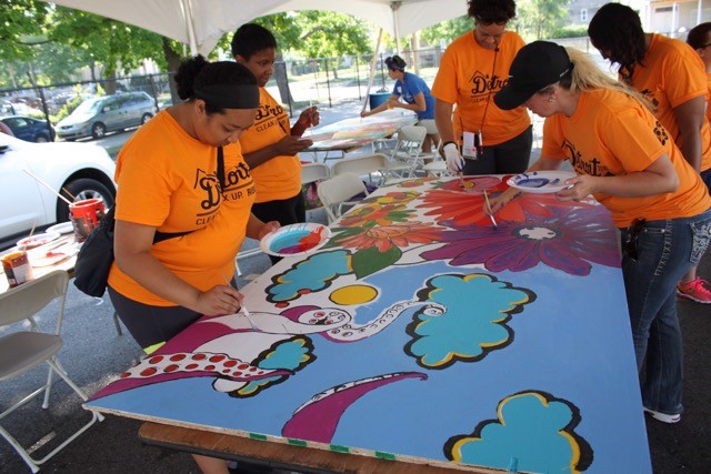 Five volunteers paint a mural in Detroit