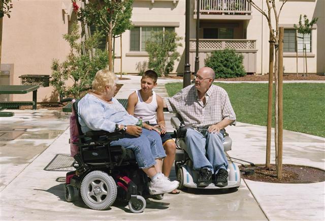 An elderly man and women sitting with a young boy.