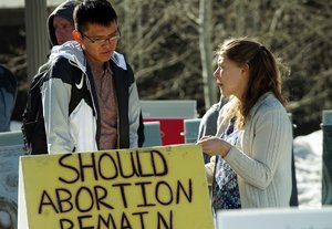two college students at table with abortion poll