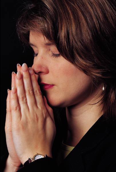 woman praying, eyes closed