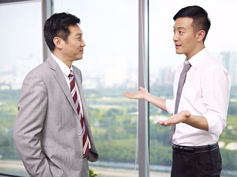 Two men in business attire having a discussion.