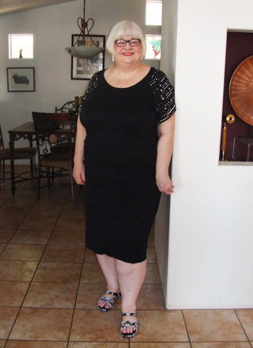 Pic of Peggy Howell, a smiling fat white woman, on her 74th birthday wearing a black dress and glasses