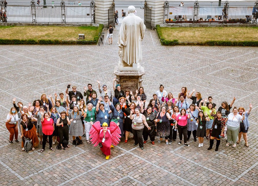 Group photo of participants from 16 countries who attended the 2022 International Weight Stigma Conference. The group is gathered on the courtyard of the historic Senate Hall at Humboldt University in Berlin. Photo by Henning Hattendorf, courtesy of Gesellschaft gegen Gewichtsdiskriminierung (the German Association Against Weight Discrimination)