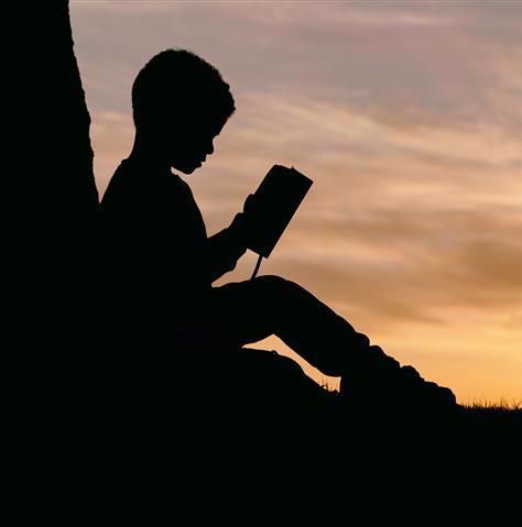 Child reading in silhouette