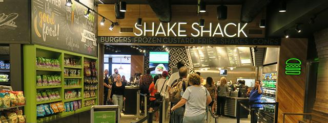 Image of guests in line for the Shake Shack now open in Terminal 3. The Shake Shack sells burgers, frozen custard, fries, shakes, and cones.