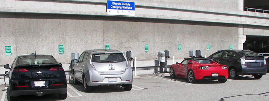 Picture of electric vehicles parked in stalls with chargers.