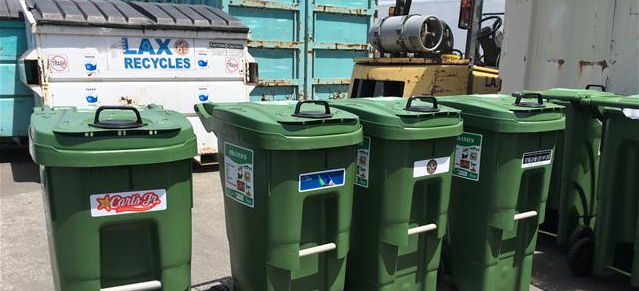 Picture of large green recycle bins from various terminal restaurants.