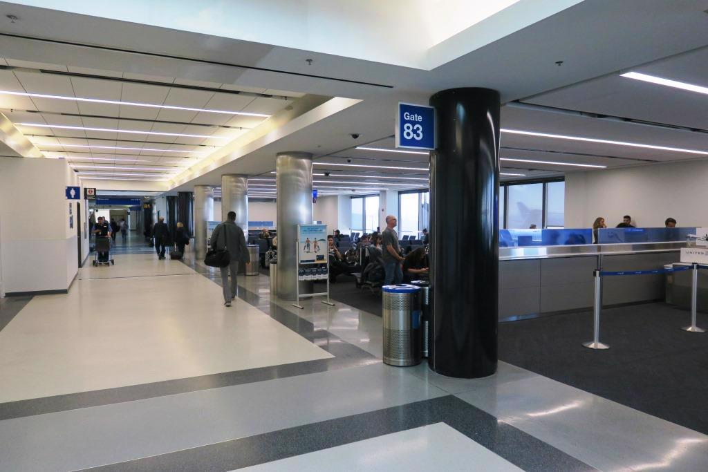 Center of image is a walkway that connects the gates in terminal 8, to the right is gate 83 sitting area with guests waiting for their flight to arrive.